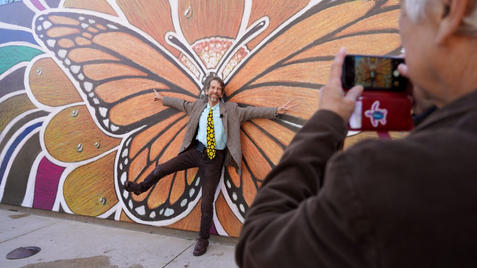 Robert Opel poses for a photo on Oct. 19 in front of his mural, “Wings of Joy,” which was the winning artwork for The Catholic Foundation’s 2022 Art On The Plaza competition. The mural will remain on display for one year in The Catholic Foundation Plaza, located behind the Cathedral Shrine of the Virgin of Guadalupe in the downtown Dallas Arts District. (Michael Gresham/The Texas Catholic)