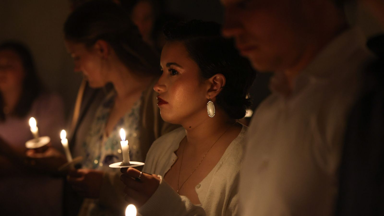 Donna Boy joins others in holding candles at the University Catholic Center at The University of Texas at Dallas the start of the Easter Vigil Mass on March 30. (Michael Gresham/The Texas Catholic)