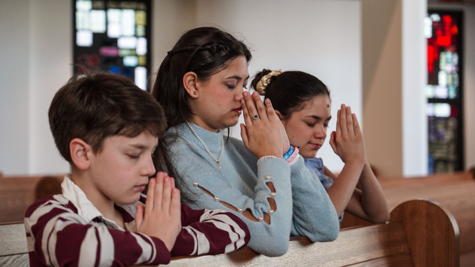 Zoie Garcia, center, prays with younger siblings Kal Garcia, left, and Saylah Garcia in the chapel at St. Elizabeth Ann Seton Catholic Church, Zoie’s “favorite place in the whole world.” The three siblings were received into the Catholic Church at St. Elizabeth Ann Seton in Plano on March 30 during the Easter Vigil Mass. (Amy White/The Texas Catholic)